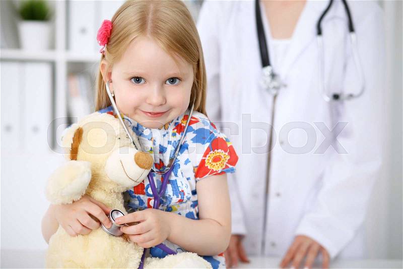 Little girl examining her Teddy bear by stethoscope. Health care, child-patient trust concept, stock photo