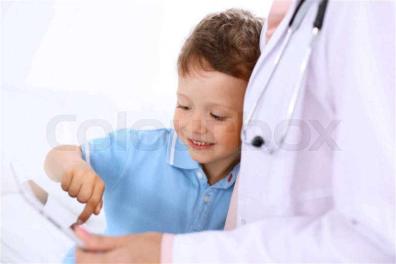 Happy little boy with his doctor after health exam, stock photo