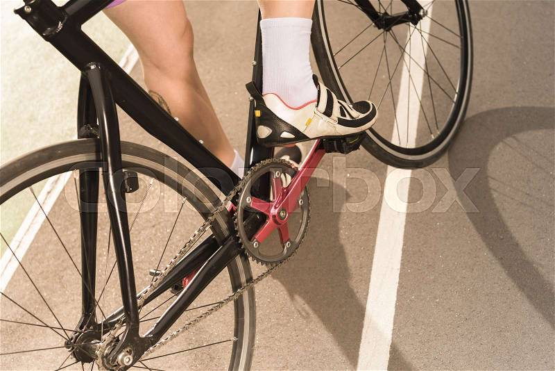 Partial view of cyclist riding bicycle on cycle race track, stock photo