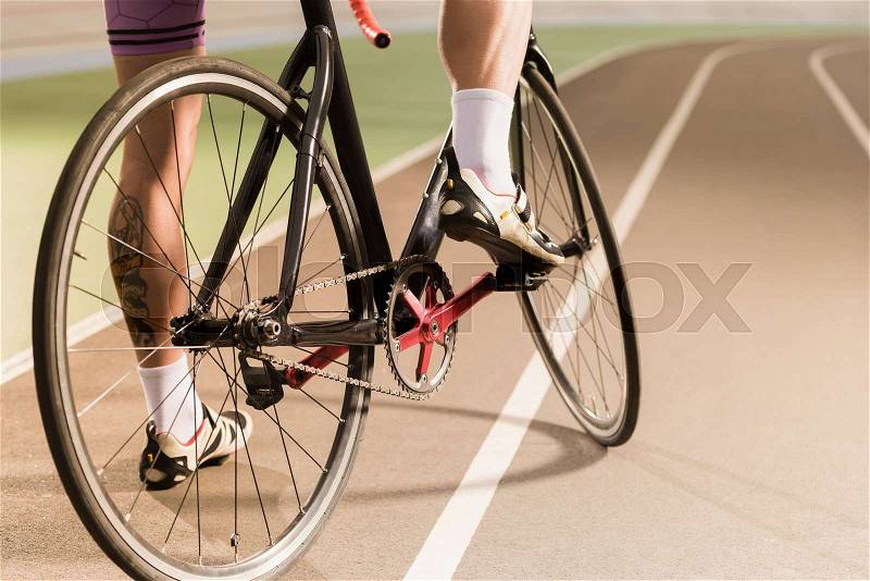 Partial view of cyclist riding bicycle on cycle race track, stock photo
