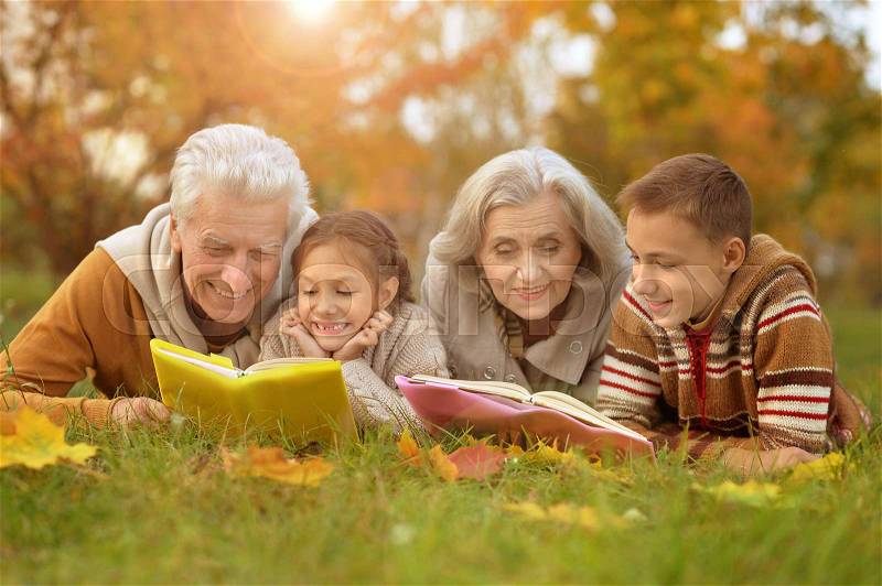Grandparents spending time with grandchildren outdoors in autumn, stock photo