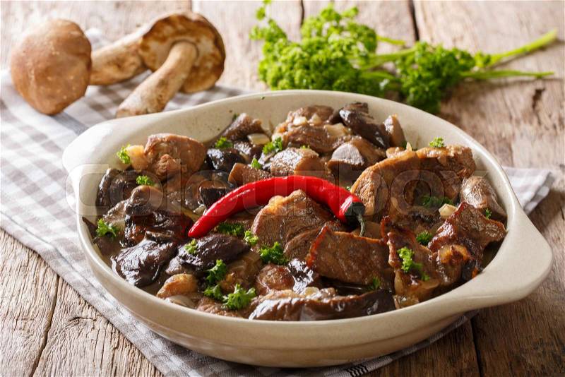 Delicious food: beef stew with wild mushrooms in spicy sauce close-up in a bowl on the table. horizontal , stock photo