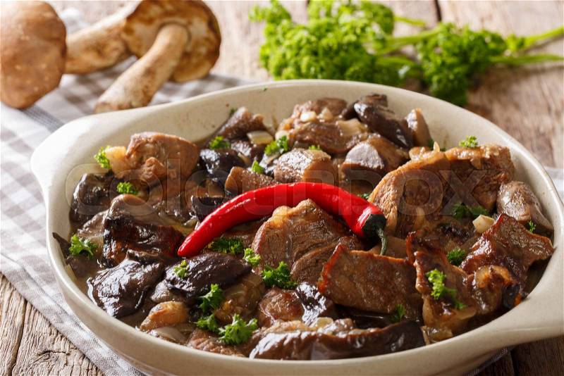 Beef stew with wild mushrooms, onion and chili pepper in spicy sauce close-up in a bowl on the table. horizontal , stock photo