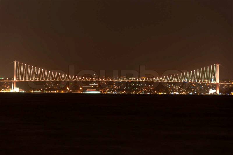 Illuminated Bosporus Bridge at night in Istanbul, Turkey, stock photo