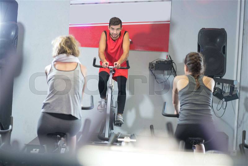 Fit people in a spin class at the gym, stock photo