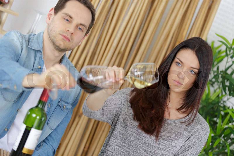 Couple is wine tasting on couch, stock photo