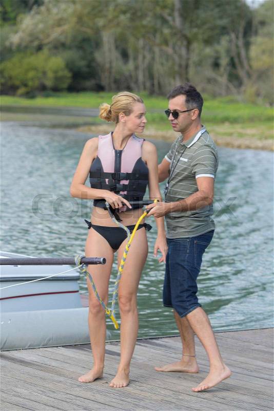 Pretty girl learning water ski theory before action, stock photo