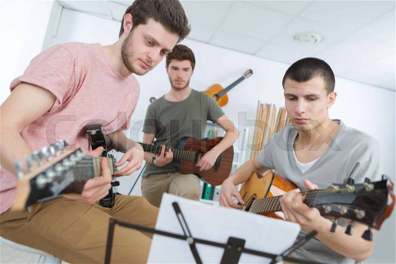 Home band learning new song together, stock photo