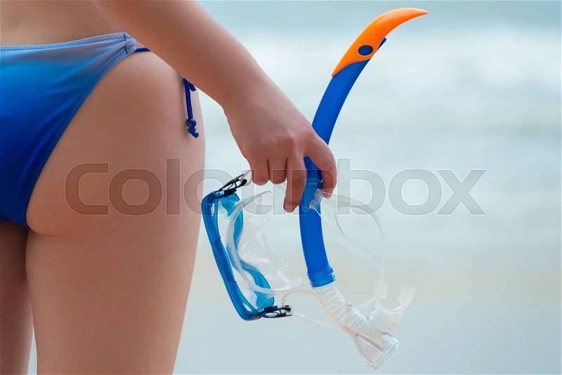 Female priest in bikini and mask for diving in hand close-up, stock photo