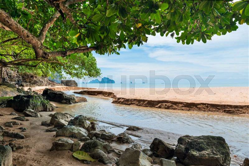 A small river flows towards the sea and flows into it, stock photo