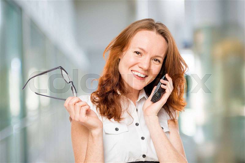 Successful secretary talking on the phone with a client company, stock photo