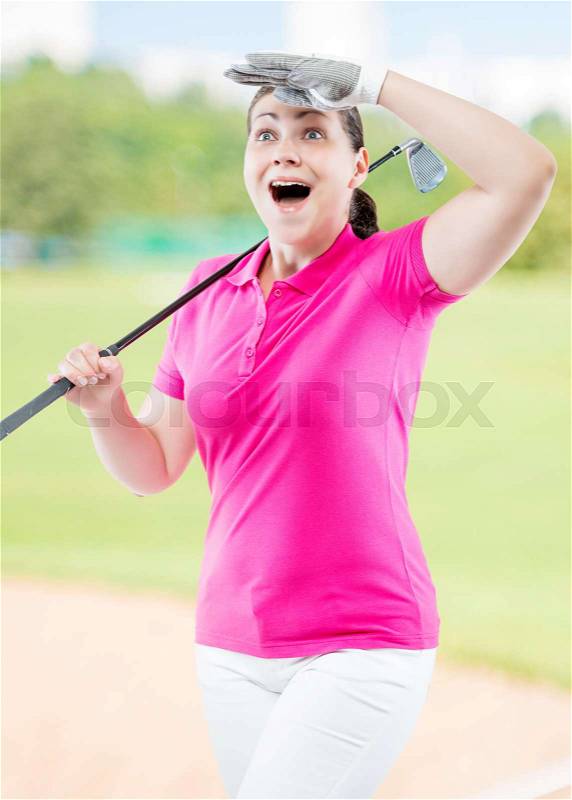Athlete woman watching the ball flight path of golf on a background of golf courses, stock photo