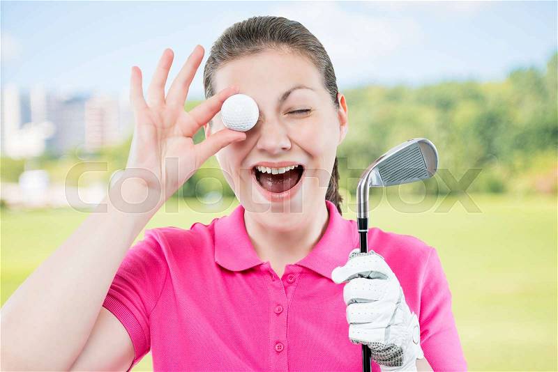 Woman golfer funny portrait on a background of golf courses, stock photo