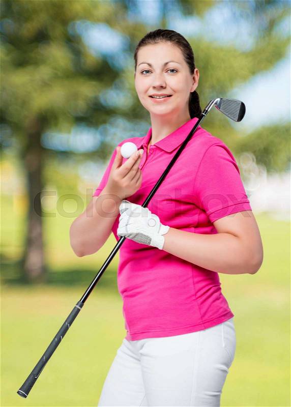 Young professional golfer posing on a background of golf courses, stock photo
