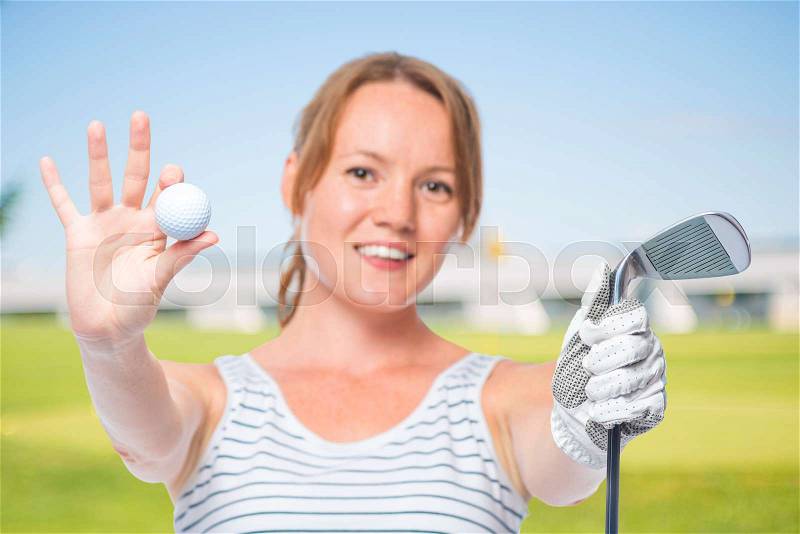 Smiling girl shows a camera in the ball and a golf club on a white background, stock photo