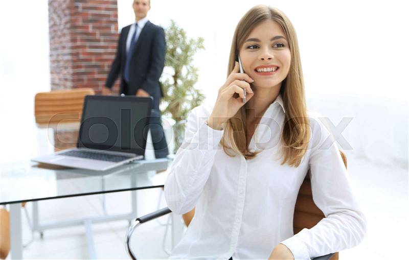 Closeup.female assistant talking on mobile phone in office. photo with copy space, stock photo
