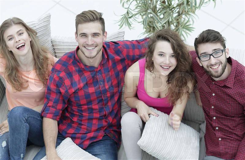 Group of friends with pillows, sitting on the couch in the living room, stock photo