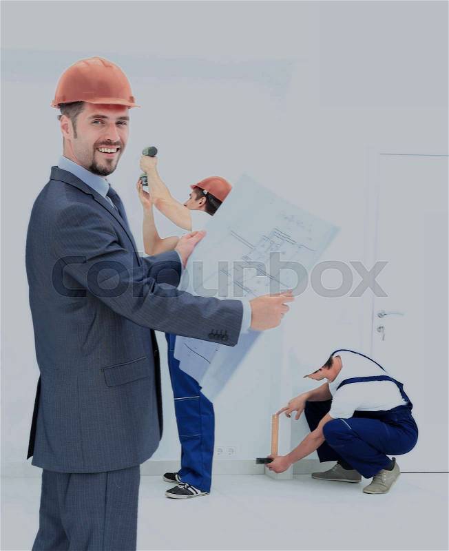 Engineer studying blueprints against the backdrop of a team b, stock photo