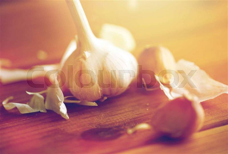 Health, food, cooking, traditional medicine and ethnoscience concept - close up of garlic on wooden table, stock photo