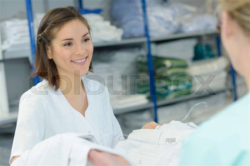 Woman passing clean laundry, stock photo