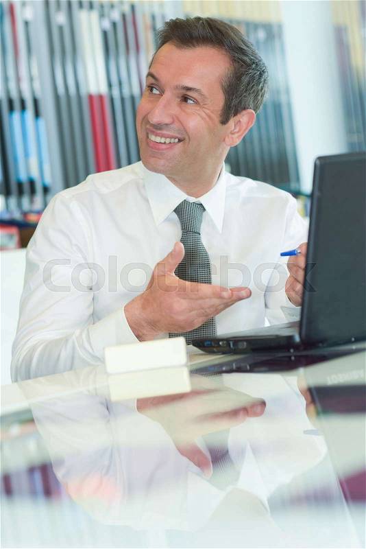 Happy businessman is working in his office, stock photo