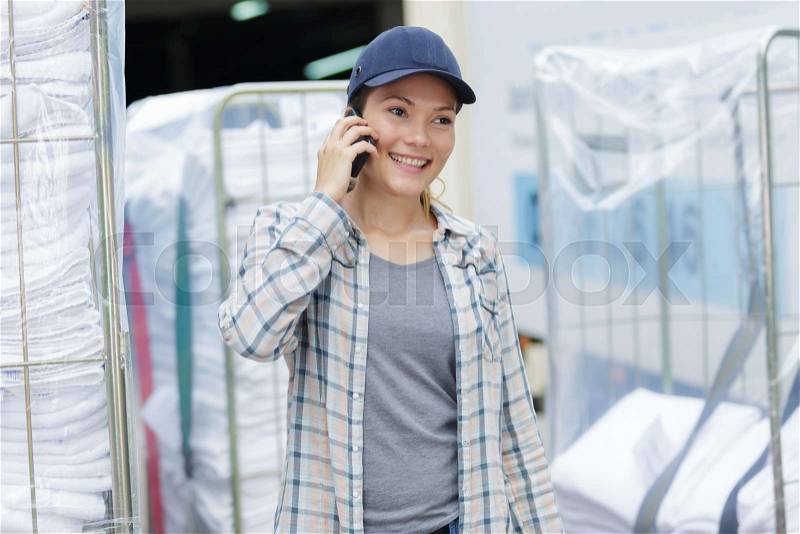 Laundry worker talking on phone, stock photo