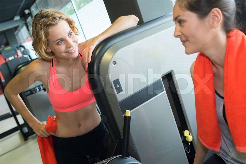 Sporty woman in gym with female coach, stock photo
