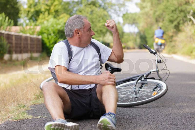 Man falls off his bicycle cross on track, stock photo