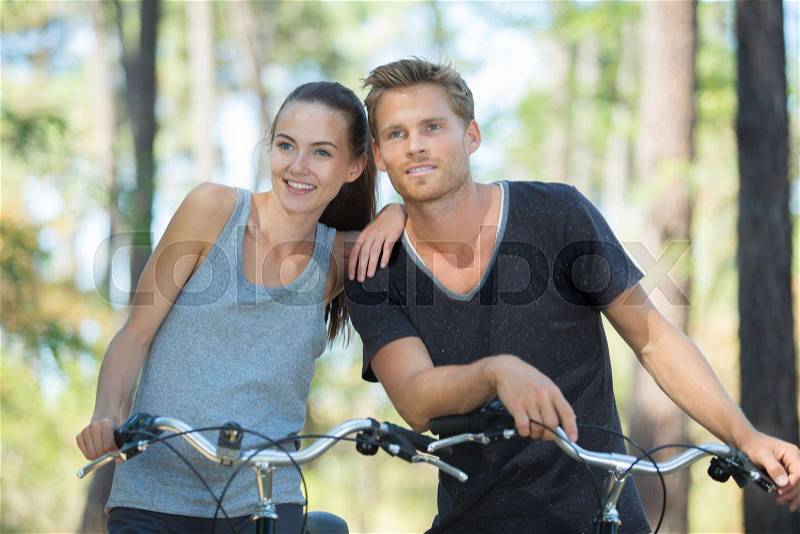 Young couple with bicycle in forest, stock photo