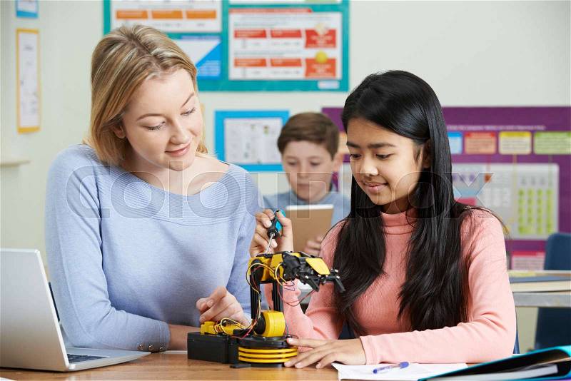 Teacher With Female Pupil In Science Lesson Studying Robotics, stock photo