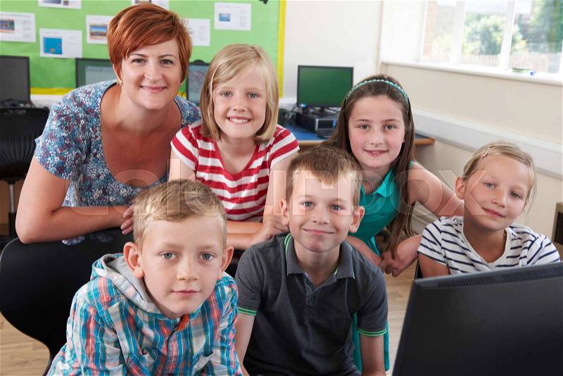 Portrait Of Elementary Pupils In Computer Class With Teacher, stock photo