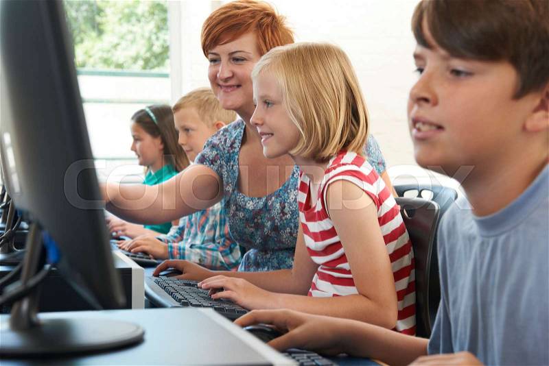 Female Elementary Pupil In Computer Class With Teacher, stock photo