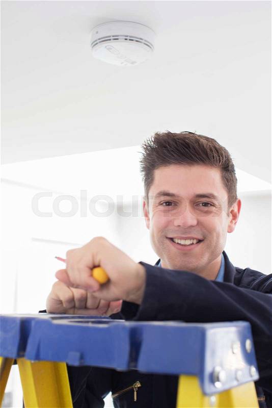 Man Installing Smoke Or Carbon Monoxide Detector, stock photo