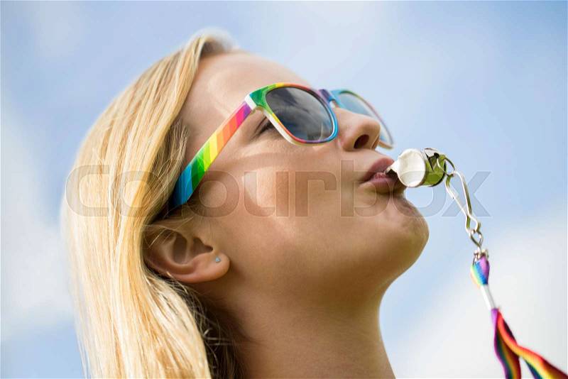 Young Woman Blowing Whistle On Gay Pride Parade, stock photo