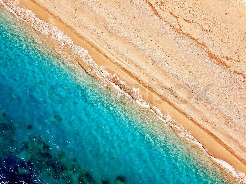 Top view of a deserted beach. The greek coast of the Ionian Sea. Aerial photo of sea waves reaching shore, stock photo