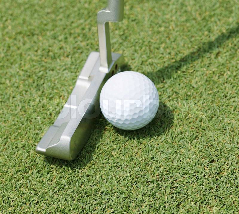 Golf club about to putt a ball, stock photo