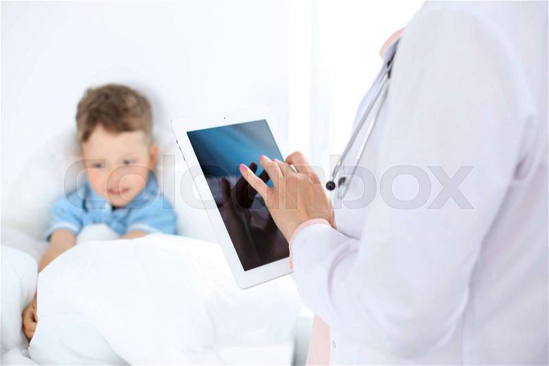 Female doctor using a digital tablet, close-up of hands. Health care concept or children\'s therapy, stock photo