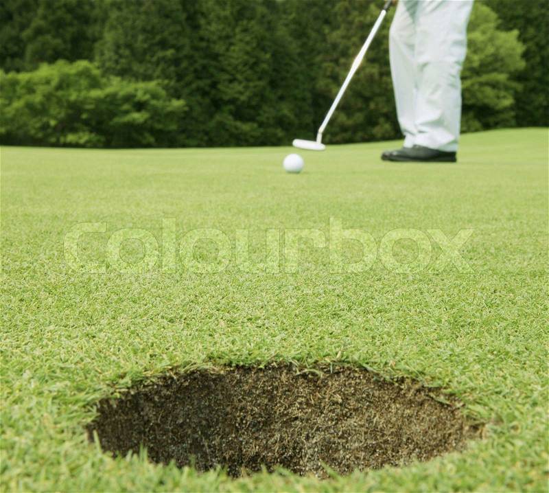 Man putting in a game of golf, stock photo