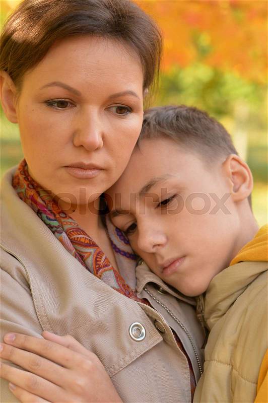 Portrait of sad mother and son outdoors, stock photo