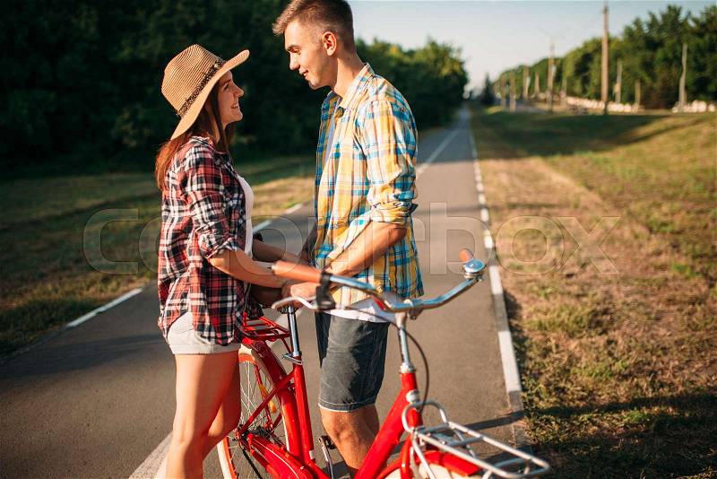 Love couple with vintage bicycle walking in summer park, romantic date of young man and woman. Boyfriend and girlfriend together outdoor, retro bike, stock photo