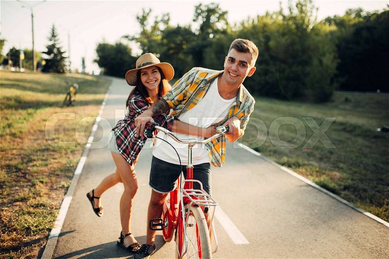 Love couple fun together in summer park, vintage bicycle, romantic date of young man and woman. Boyfriend and girlfriend together outdoor, retro bike, stock photo