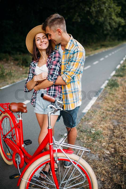 Love couple walk on vintage bikes, romantic journey of young man and woman. Boyfriend and girlfriend together outdoor, retro bicycle, stock photo