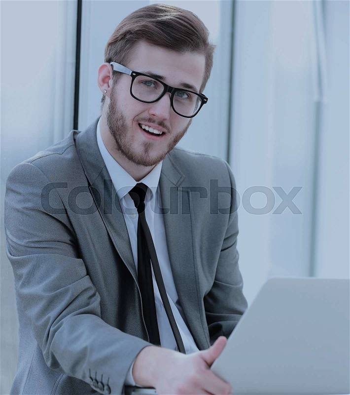Happy young business man work in modern office on computer, stock photo