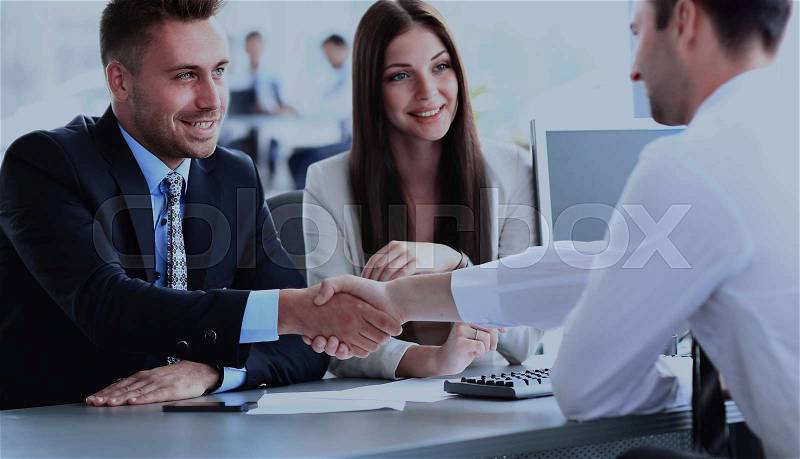 Businessman shaking hands to seal a deal with his partner, stock photo