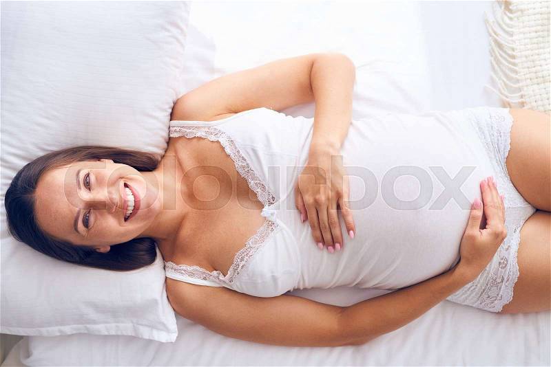 High angle of cheerful future mother wakes up in the morning full of energy, stock photo