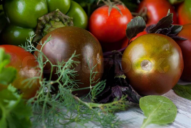 green and red color vegetables, Black and red tomatoes, green and red peppers, fragrant herbs on an old wooden table, Top view, copy space, stock photo