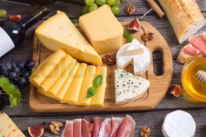 Different kind of cheese with wine, figs, walnuts, jamon, stock photo