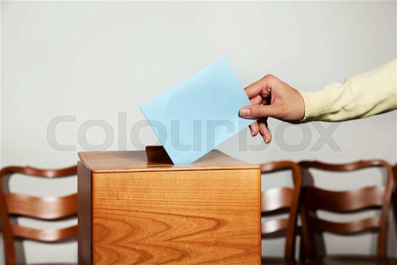 A young woman with a voter in the voting booth voting in a democracy, stock photo