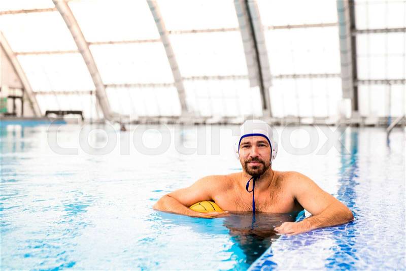 Water polo player in a swimming pool. Man doing sport, stock photo