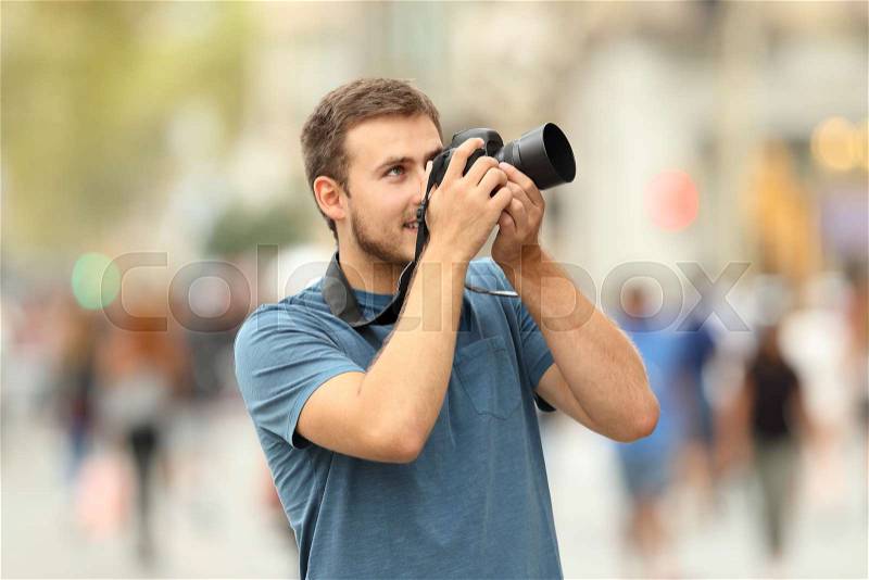Happy photographer taking photos on the street with a dslr camera, stock photo